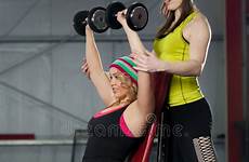coach female assists dumbbells gym training stock