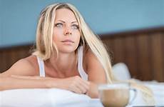 kvinnan blonda säng morgonkaffe unga dricker
