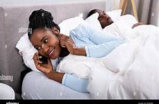 while husband woman bed talking cheating sleeping cellphone african young her bedroom stock alamy boyfriend