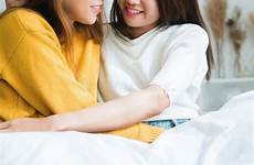 beautiful hugging asian lgbt smiling sitting lesbian couple bedroom together bed happy young women preview