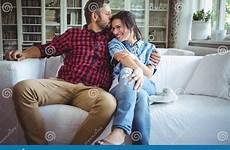 kissing man woman sitting sofa living room while preview