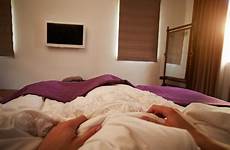 bed person point sleeping man stock phone angle television watching looking