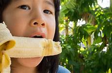 banana child asian eating girl bite joy eat chew concept stock similar
