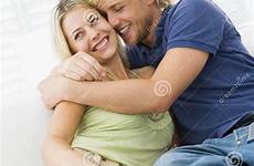 hugging smiling couple living room stock