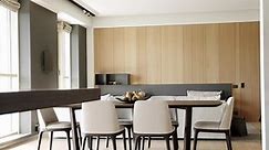 Modern Kitchen room with minimalist dining table.Minimalist kitchen room in white colors with dining area of natural wood.Light Wood Wall and Floors.Modern kitchen and bar brown chairs in kitchen room