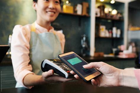 Customer Paying With Smartphone by Clique Images