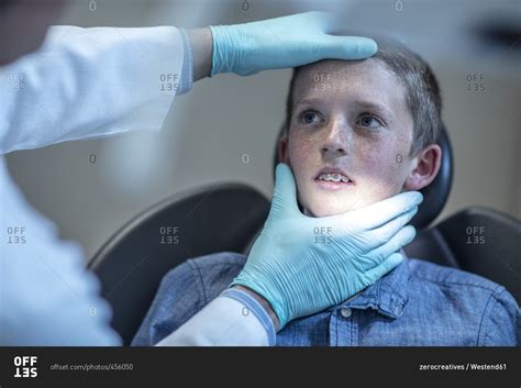 And oral and maxillofacial surgeons, who specialize in face, mouth and jaw surgery. Nervous boy with braces in dental surgery looking at ...