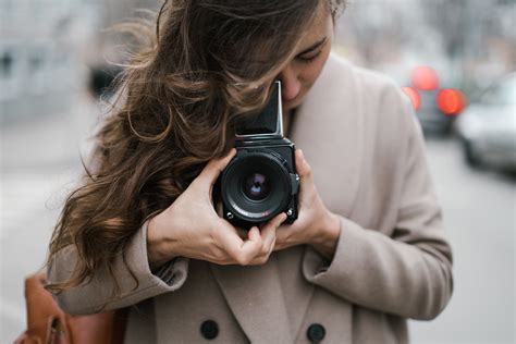 Young woman taking photos with old fashioned camera on street · Free ...