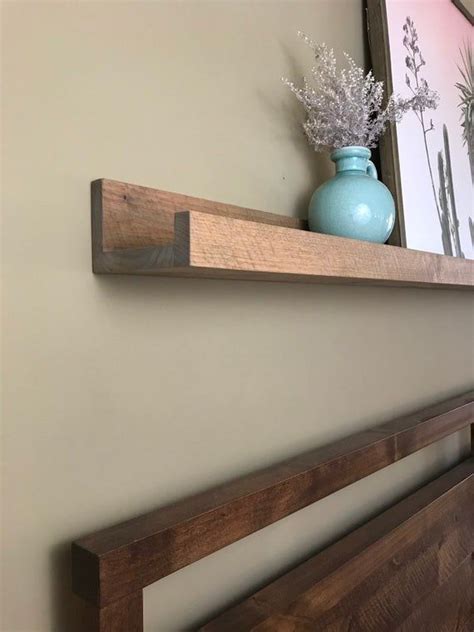 Floating shelves with upturned ledges provide extra support for whatever modern decorations or memorabilia you choose to display—arrange leaning picture frames on the living room wall or line. Picture Ledge // Picture ledges // Floating Shelves ...