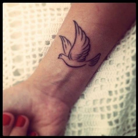 Two flying dove tattoo holding heart in the center of chest. 21 Fantastic Dove Tattoos On Wrist