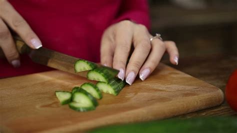 Shaved sides with longer on top. Woman cutting cucumber - Free Stock Video - Mixkit