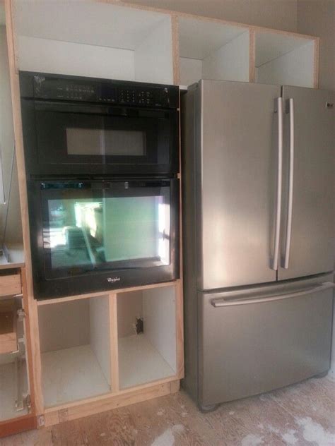 Cabinets are attached and hung on the walls. Wall oven cabinet before door installation | Oven cabinet