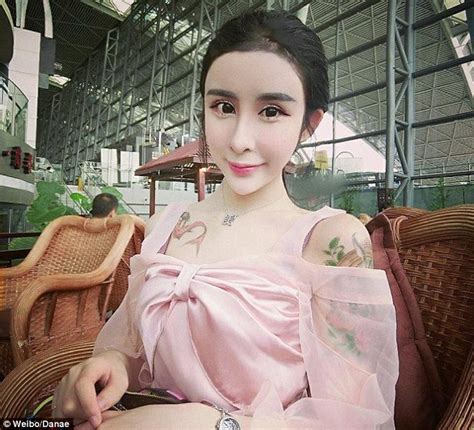 Girl in classroom examining flower with magnifying glass, germany. China teen who has undergone extensive plastic surgery's ...