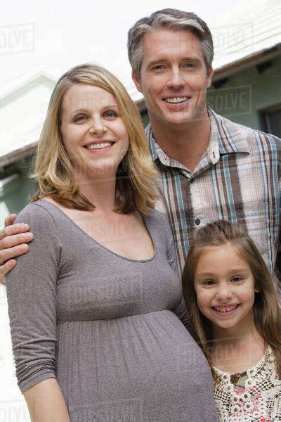 What to look for in a pregnancy tracker app for expecting moms, dads, parents. Pregnant mother, father and daughter (6-7) posing for ...