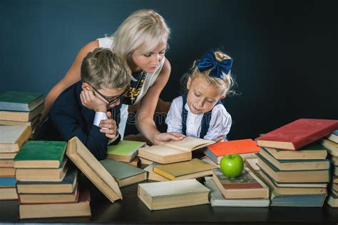 All models appearing on this website are 18 years or older. Mother Or Teacher Helping For School Kids Doing Homework ...