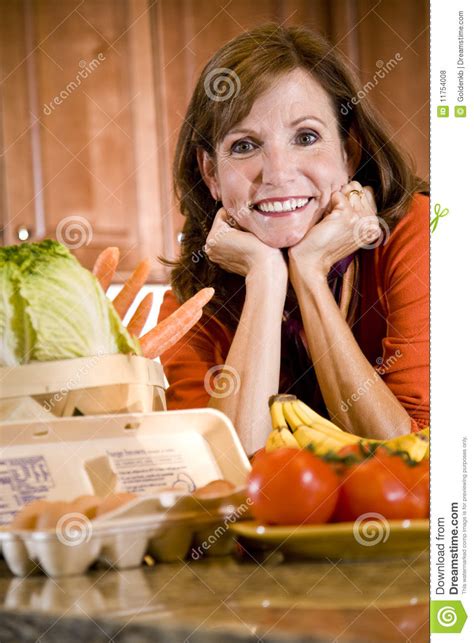 Prima di servire, decorare con erbe fresche. Donna Matura In Cucina Con Gli Ingredienti Freschi ...