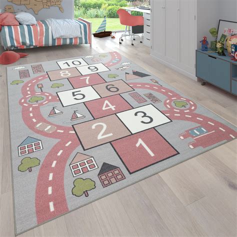 Eine handgewebte baumwollspielmatte mit straßen für kinder, um ihre autos zu fahren und ihre puppen für einen spaziergang entlang der illustrierten landschaft zu nehmen. Kinder-Teppich Straßen-Motiv Hüpfkästchen | teppich.de