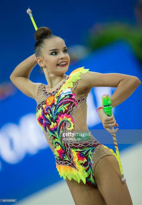 Rhythmic gymnastics is a sport in which gymnasts perform on a floor with an apparatus: Russian Dina Averina performs the clubs exercise during ...