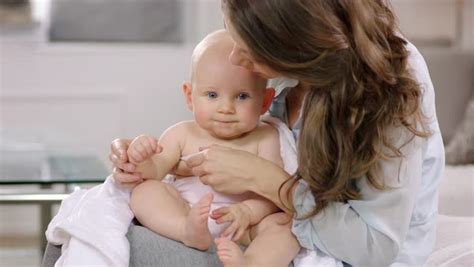 The tip of the thermometer must stay covered by skin. Mother taking baby girl's temperature with a digital ...