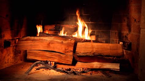 Wooden table next to grey corner settee in warm living room interior with painting and fireplace. Fireplace for Your Home, Hour-Long Videos of Crackling ...