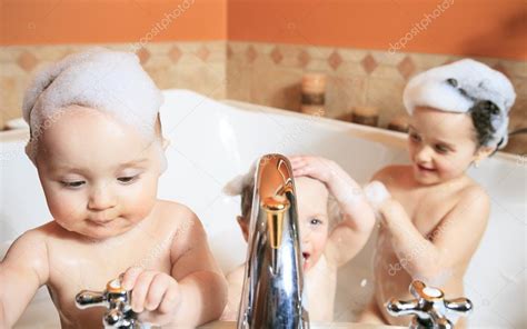 Check the bath water temperature first before putting your baby in. Funny little girl and her cute baby brother having fun ...