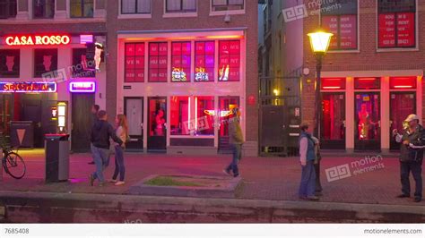 Women sit openly behind windows, lit by red lights, attracting customers. Amsterdam netherlands red light district-porno archive
