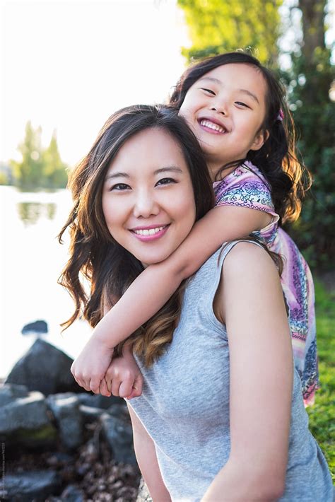 I just enjoy spending time with them. Happy Asian mother and daughter having fun together by ...