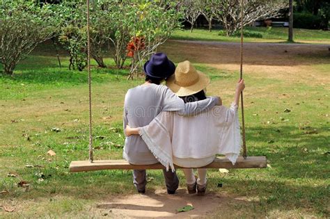 Old swinging couple seduces young whore. Young couple on a swing stock photo. Image of caucasian ...