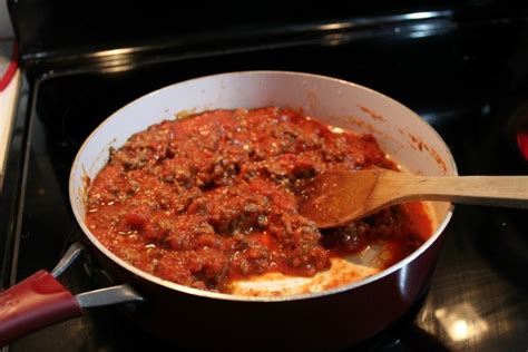 Make baked spaghetti by first cooking ground beef and mild italian sausage in a pan. Baked Spaghetti meat and pasta sauce