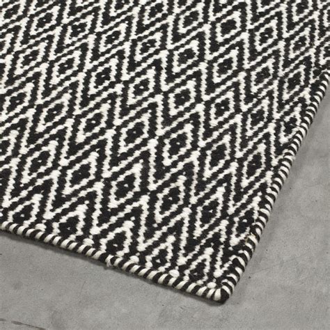 Avec ses dimensions généreuses (90 x 200 cm) et ses coloris sobres, il sera parfait dans toutes les pièces de la maison : Tapis angelo noir mic mac en laine tissé main 140x200