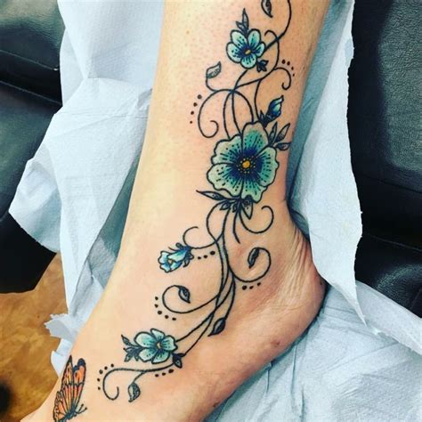 Fiore blu violetto con foglie a spada. tatuaggio alla caviglia, un disegno raffigurante delle ...