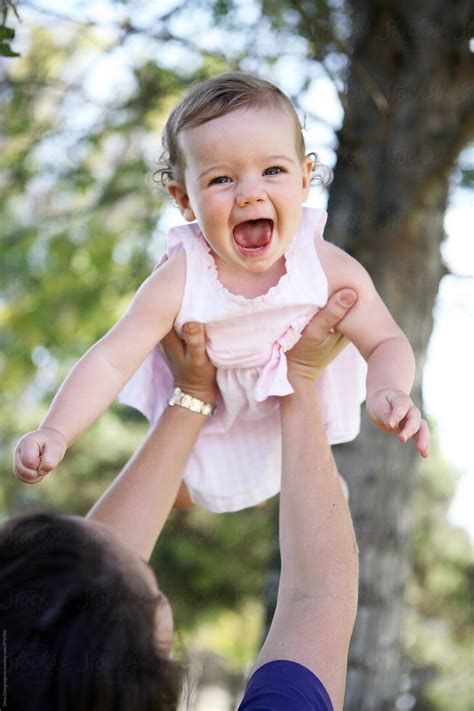 «Mom Holding Very Happy Baby Girl In The Air» del colaborador de