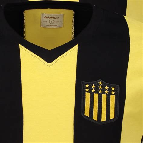 Het shirt is zwart met een gele print en het clublogo. Peñarol Retro 1961 T-Shirt