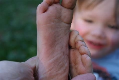 Little boy showing off his dirty feet sitting on a step holding them out to the camera with their muddy soles after playing barefoot in the garden. Dirty Feet Boy | Laurel | Flickr