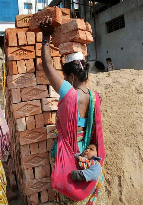 You can use the following text Image shows woman carrying bricks on head and baby on back ...