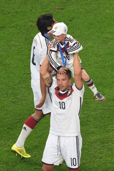 Podolski kinder lukas podolski gibt seiner tochter einen kuss. Germany's forward Lukas Podolski lifts a child onto his ...