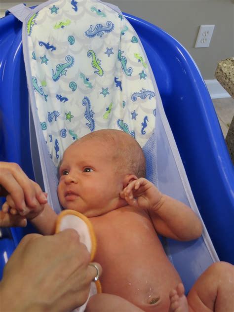 Then, lower him into the water with the towel still on. Little Baby Kinard: A Month of Firsts (1 month old)