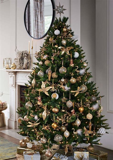 Artificial trees give you that extra level of customisation that you just don't get with real trees. With a glittering star topper, this opulent gold Christmas tree shimmers with desert-inspire ...