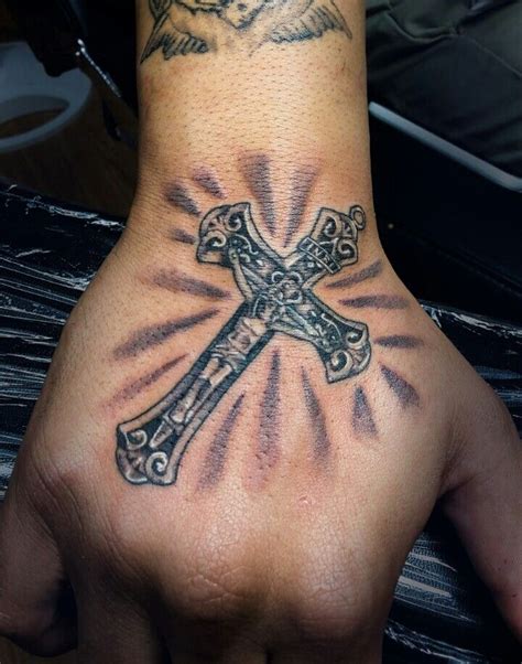 Raised by a hand towards the heavens is a wooden cross tattoo design, as if emitting rays of light amidst white clouds as a backdrop. Crucifix Hand tattoo Mister Placaso | Hand tattoos ...