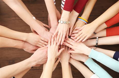 Group of people hands together on wooden background | ECARF