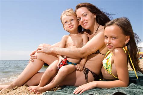 A young woman invites a filmmaker to follow her through the modern world of nudism. Young Mom With Kids At The Beach Resort Stock Photo ...