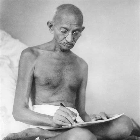 Mahatma Gandhi sitting in yoga posture wearing dhoti and writing at ...