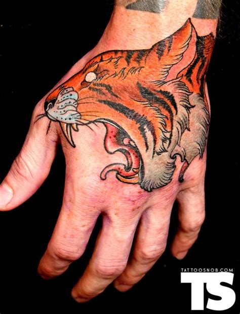This #tattoo is perfect to show off your #masculinity. Tiger hand tattoo by Javier Rivera | Tattoo References ...