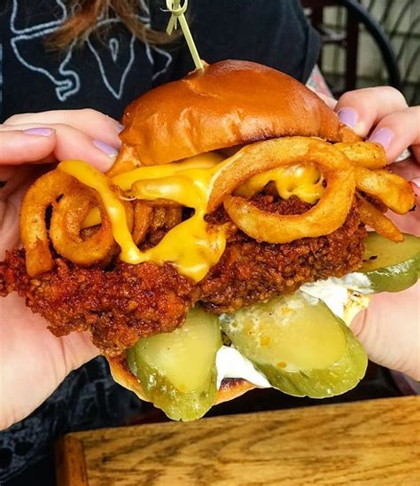 Nashville style hot chicken takes classic, buttermilk marinated, fried chicken and covers it in a sweet, tangy and spicy cayenne glaze. Nashville hot Fried Chicken Sandwich stacked with curly ...