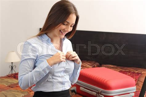 Teen in pink top and her mate in grey dress. Businesswoman traveler undressing in a hotel room after a ...