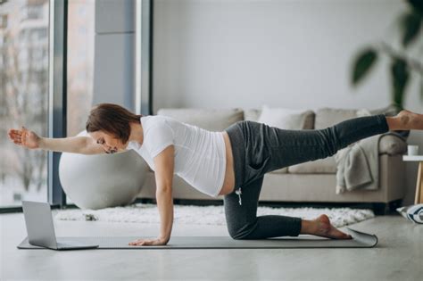 1 gerät für den ganzen körper mehrere übungen für bauch, peine. Schwangere frau, die yoga zu hause ausübt | Kostenlose Foto