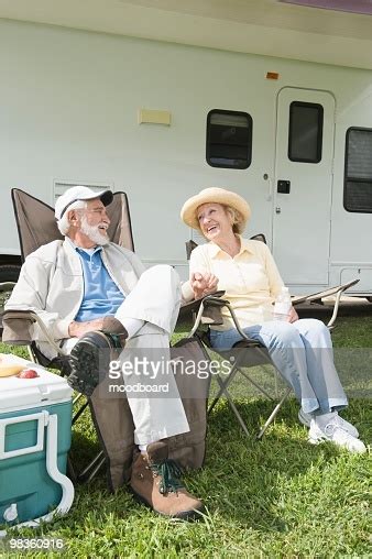 The rv, short for 'recreational vehicle,' is a vehicle with a living space attached. Senior Couple Sit Outside Rv Home Stock Photo | Getty Images