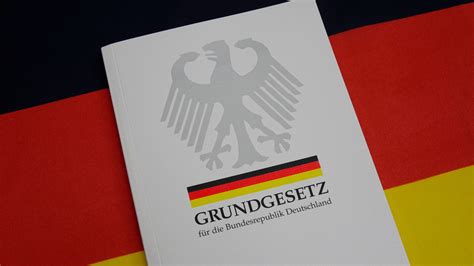 Es beschreibt, wie gewählt wird und wie gesetzte erlassen werden. Grundgesetz auf einer Deutschlandfahne - B.Z. Berlin