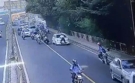Jilbab putih segara kuangkat di bagian dadanya. Polis trafik 'lekat' di atas bonet hadapan ketika cuba ...