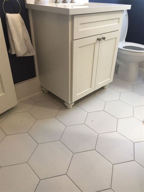 White diamond pattern tiles with light gray grout in a bathroom finished with a beveled vanity mirror, a vintage cross handle faucet and a pedestal sink. Pin on Cardinal Construction & Design by Karen Travelstead